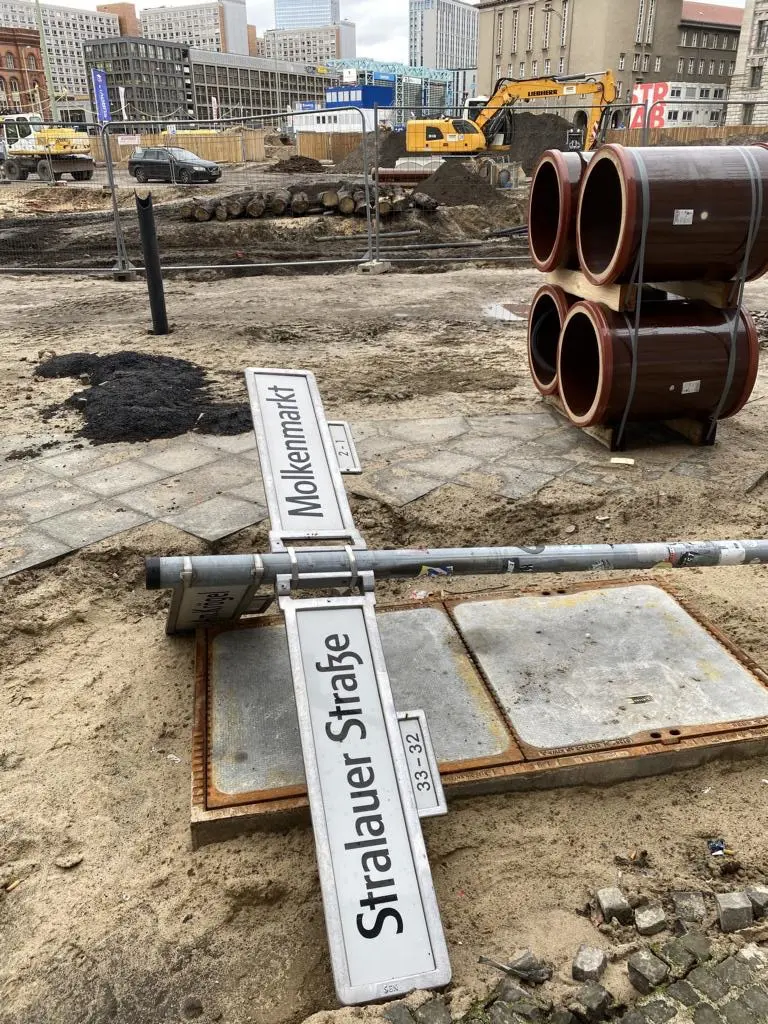 Buntes Treiben in Berlin: Märkte. Einige Holzbohlen der mittelalterlichen Straße wurden bereits herausgerissen, um entsorgt zu werden. Sie liegen am Rand der Ausgrabungsgrube.