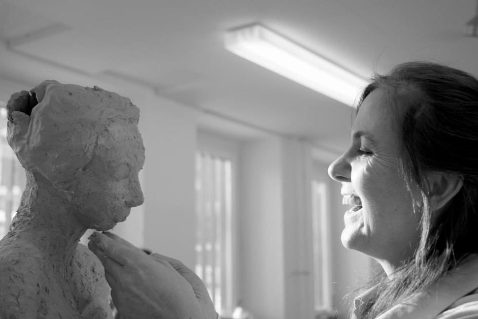 Arbeitsbeispiel Werde EinzigArtist: Beim Onlinekurs geht es Bettinelli, durch Positionierung ihre Einzigartigkeit herauszuarbeiten. Auf dem Bild zeigt sie sich bei der Arbeit an einer Figur in ihrer Keramikwerkstatt, die ihr offensichtlich viel Spaß bereitet.