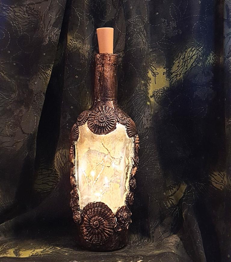 Meine 12von12 im September 2022: Ruby Bachert-Schneider freut sich an ihrer frischen Errungenschaft. Sie hat ein Ornament rund um eine Flasche geschaffen, damit sie Steampunk gemäß leuchten kann.