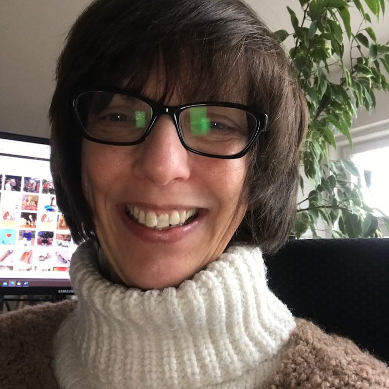 Ab ins Museum. Dort zuvor stelle ich noch schnell meinen Beitragsbeginn ins Netz! Das bin ich. Claudia Scholz. Es ist der 12. Februar 2023 und damit Zeit für meine #12von12! Im Hintergrund gibt es meinen Bildschirm zu sehen. Ich lächle in die Kamera im weißen Rollkragenpullover.