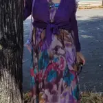 Lilo mit ihrem Kleid aus wilden lila-grün-weiß-farbenen Blüten und dem lilafarbenen Oberteil dazu scheint zu sagen: Ich habe mich versteckt. Kommt mich suchen!