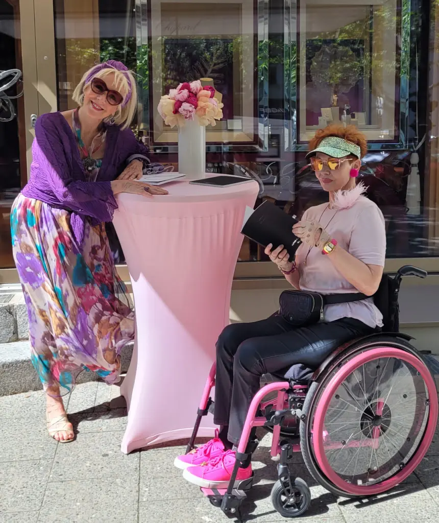 Lilo und Betty im Pink-Look beim Walk of Glam. Lilo steht am Stehtisch mit rosa Housse.