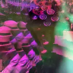 Claudia Scholz trägt ihren Steampunk-Zylinder. Im Hintergrund sitzt abgewandt Ralf Krüll, der Starfotograf.