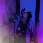 Stella Ahangi steht lässig an die Hauswand gelehnt im Eingang zu einem Haus am Ku'damm. Dieses Foto entstand durch die Prismabrille fotografiert.