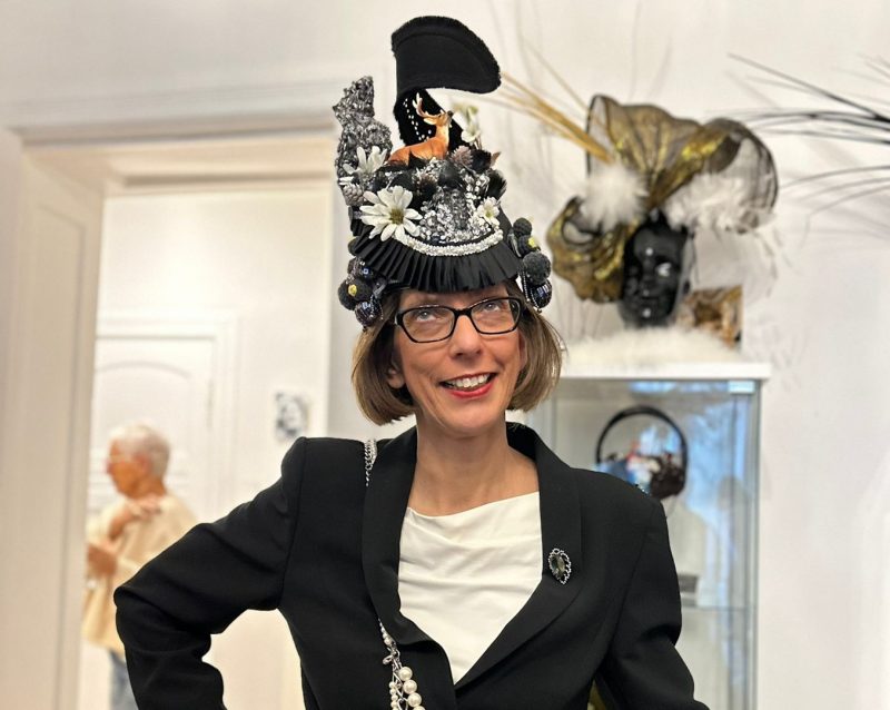 Claudia Scholz bei der Hutanprobe bei einer Hutmacherin in Berlin. Es ist eine exzentrische Kopfbedeckung