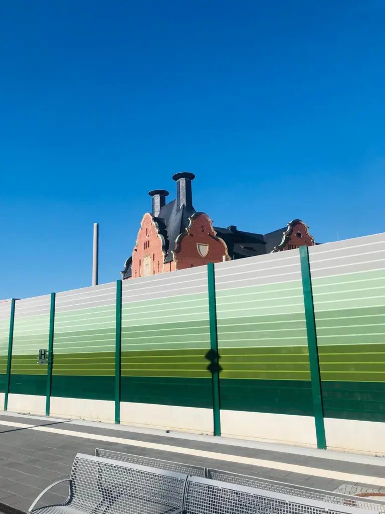 Die frische aufpolierte "Alte Mälzerei", als Wahrzeichen von Lichtenrade gehandelt, verschwindet hinter der Schallschutzmauer der Bahn.