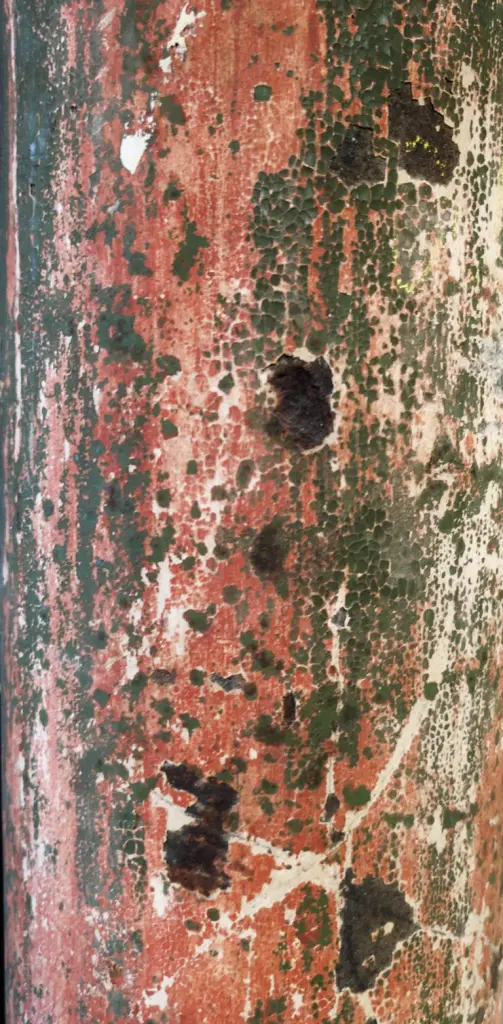 Rote Patina bestimmt die Farbe der Metallsäule im Foyer der Alten Mälzerei in Lichtenrade. Birgit Helmlinger wirft einen Blick darauf.