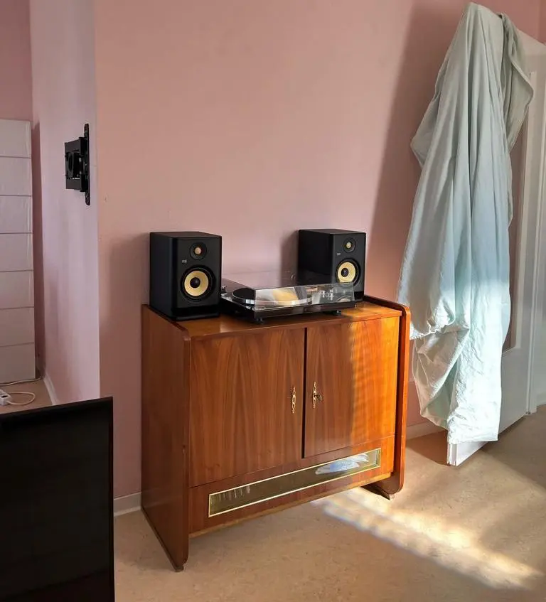Auf dem Bild des neuen Wohnzimmers steht ein Möbelstück, vielleicht aus den 50-iger Jahren - mit zwei Lautsprechern und einem Plattenspieler in der Mitte.
