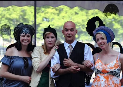 Carlos Klein mit drei Models unter einem Baldachin; die Frauen tragen seine Hutkreationen nach einer Modenschau.